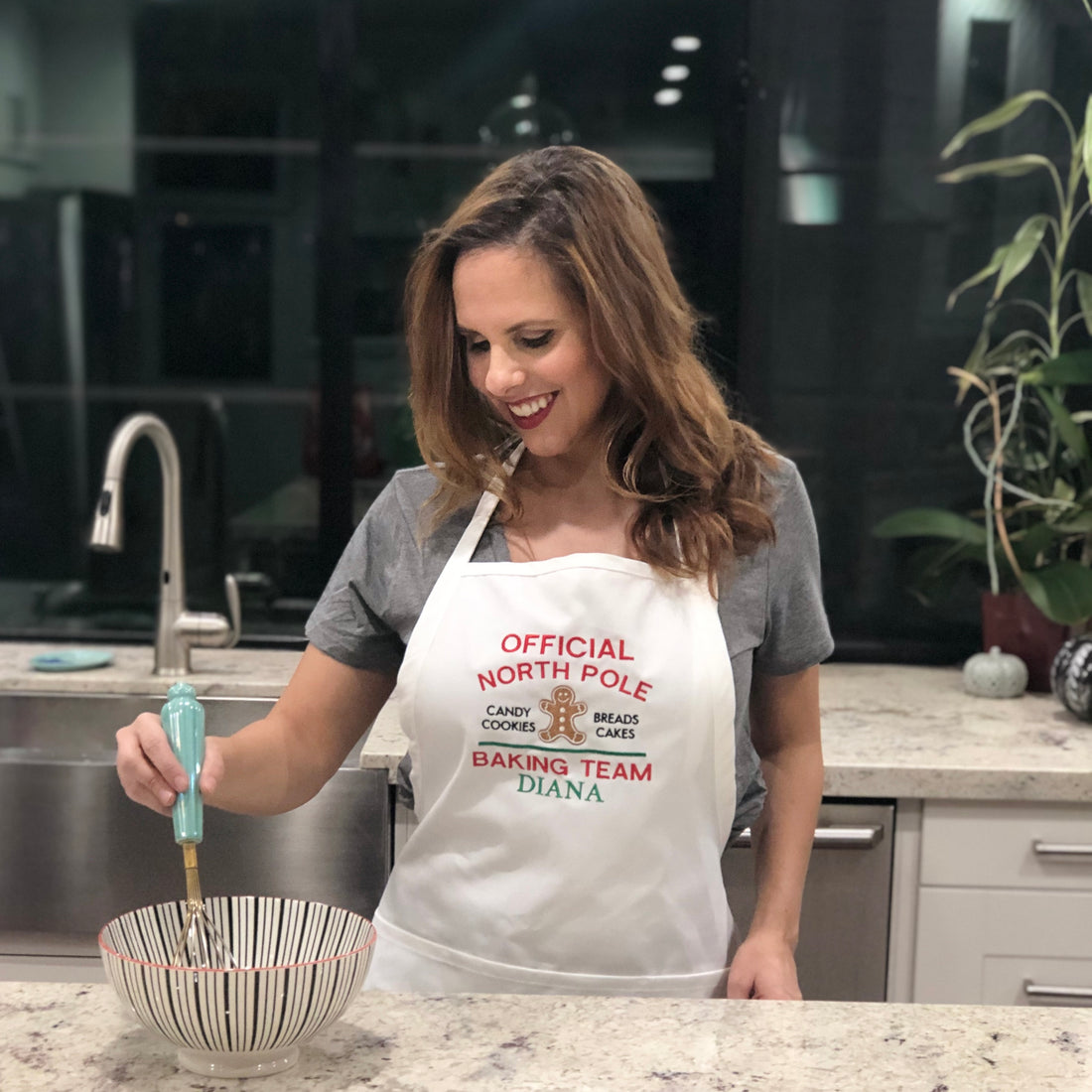 Model  wearing white North Pole Baking Team Embroidered Apron. - Life Has Just Begun